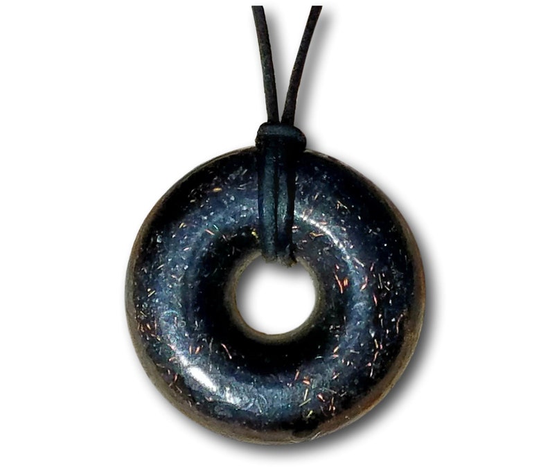 Black Sun Orgonite donut pendant necklace isolated on a white background. Handmade orgonite jewelry featuring a circular donut shape, polished black finish, and subtle metallic flecks. Includes black leather necklace cord for everyday wear.