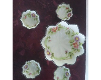 May include: Set of five white porcelain bowls with scalloped edges and floral designs in shades of pink, green, and purple.