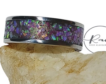 May include: A stainless steel ring with a purple and green iridescent inlay. The ring is on a white background.