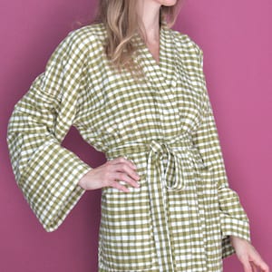 May include: A green and white gingham robe with a self-tie belt. The robe has long sleeves and a relaxed fit.