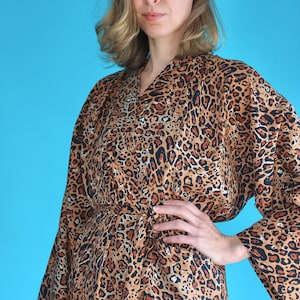 May include: A brown and black leopard print robe with long sleeves and a tie belt.