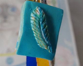 writer's feather bookmark on leaves