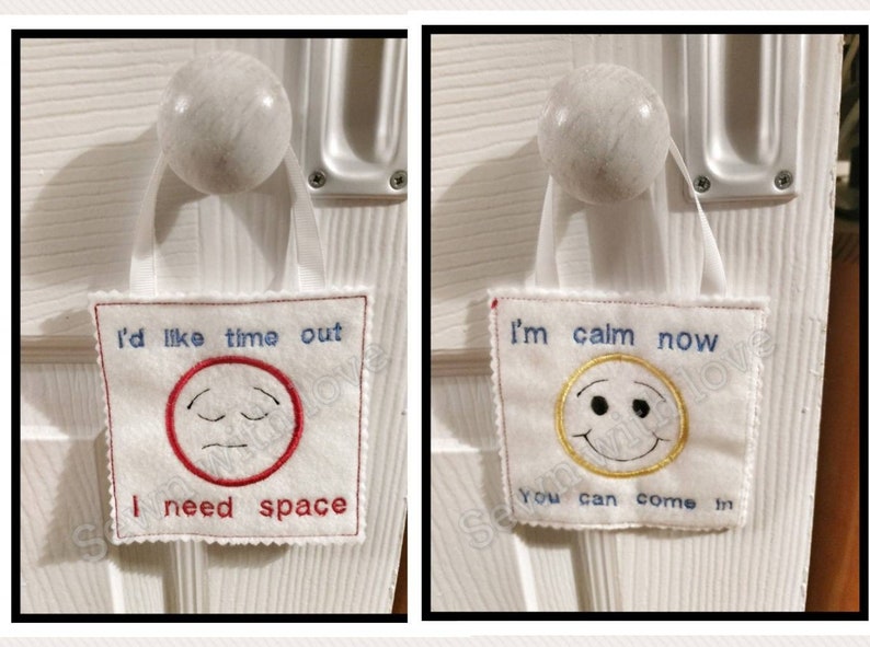 May include: Two white felt door hangers with embroidered text and smiley faces. The first hanger says "I'd like time out I need space" with a red frowning face. The second hanger says "I'm calm now you can come in" with a yellow smiling face.