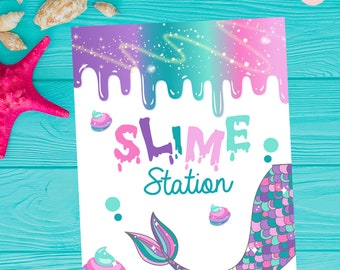 May include: A white sign with the words "SLIME Station" in pink, purple, and teal. The top of the sign has a dripping design in shades of purple, teal, and pink. A mermaid tail and decorative swirls complete the design.
