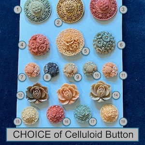 Puede incluir: Una selección de botones de celuloide en varios colores y diseños, incluyendo patrones florales y geométricos. Los botones están dispuestos en una tarjeta azul claro, con el texto "CHOICE of Celluloid Button" en la parte inferior.
