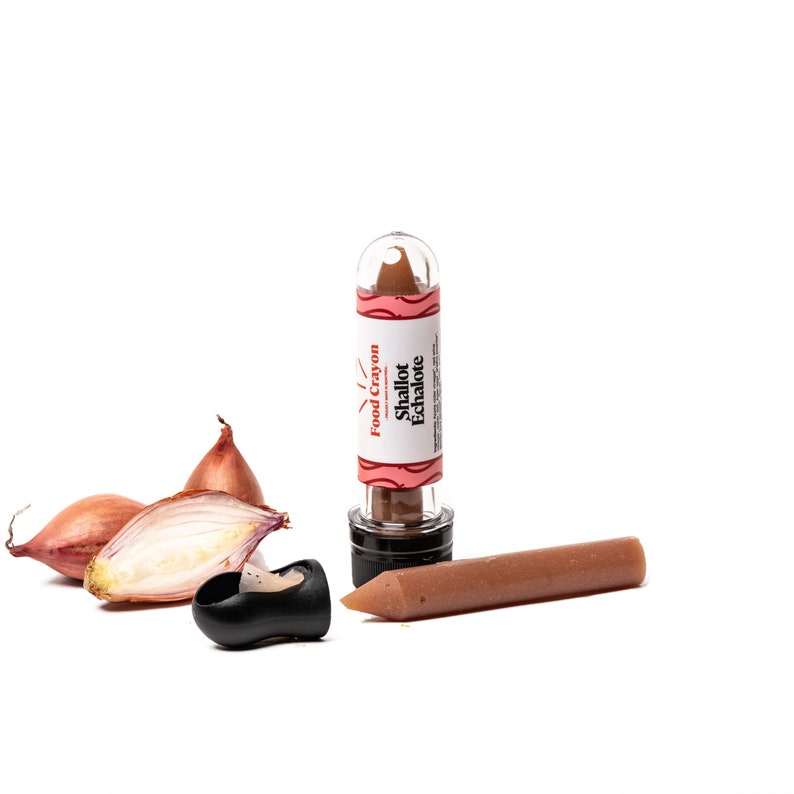 May include: A brown food crayon in a clear tube with a red and white label that says "Food Crayon" and "Shallot Echalote". The crayon is next to a small pile of shallots.