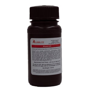 May include: A dark brown plastic bottle containing Alumi-UV resin with a black screw-top lid. The white label features the Alumi-UV logo, usage instructions, and technical specifications, including a net weight of 0.25 lb and cure time details.