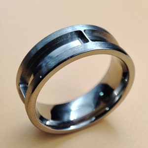May include: A brushed silver ring with a unique design featuring two parallel grooves.