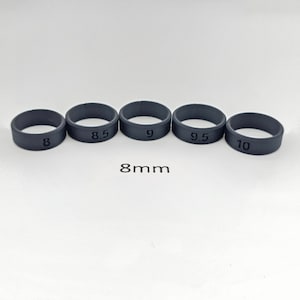 May include: Five black silicone rings with sizes 8, 8.5, 9, 9.5, and 10 printed on them. The rings are 8mm wide.