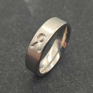 May include: A silver ring with a cut-out design of a keyhole.