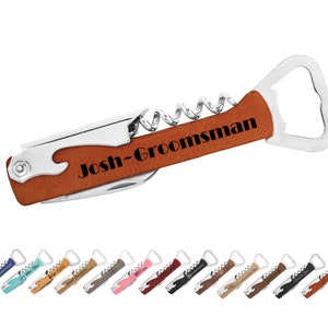 May include: A brown leather-wrapped bottle opener with a corkscrew and a bottle opener. The handle is engraved with the text "Josh-Groomsman".