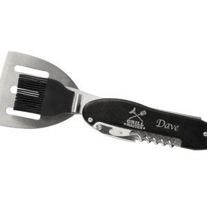 Puede incluir: Un utensilio de cocina multifunci&oacute;n para barbacoa de acero inoxidable y negro. Cuenta con una esp&aacute;tula, un pincel para untar, un sacacorchos y un abridor de botellas. El texto "GRILL MASTER" y el nombre "Dave" est&aacute;n impresos en el mango.