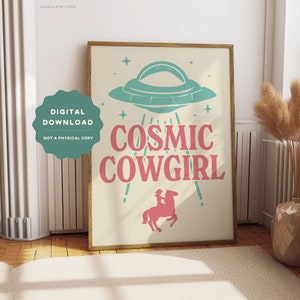 May include: A digital download print with a retro-style illustration of a UFO, a cowgirl riding a horse, and the text "COSMIC COWGIRL" in pink letters on a cream background.
