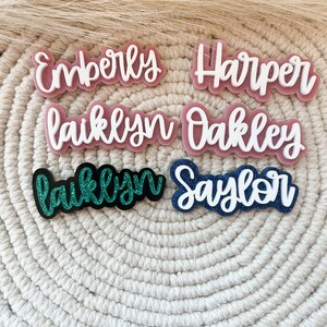 Pu&ograve; includere: Sei targhe con nome personalizzate con accenti glitter. I nomi sono "Emberly", "Harper", "Laiklyn", "Oakley", "Laiklyn" e "Saylor".