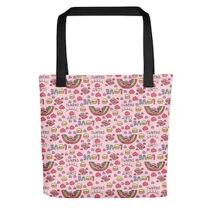 May include: Pink tote bag featuring a pattern of rainbows, hearts, lips, and the words "LOVE", "DREAMS", and "LGBT". It has black handles.