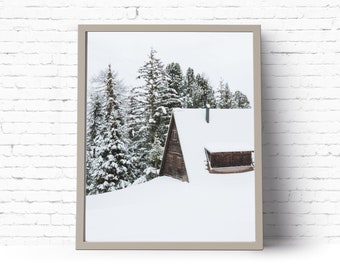 Könnte beinhalten: Eine kleine Holzhütte mit schneebedecktem Dach liegt eingebettet zwischen schneebedeckten Bäumen in einer winterlichen Landschaft.