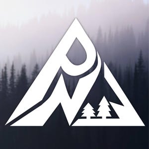 May include: A white graphic logo shaped like a triangle featuring the letters P and N integrated into the design, with two small stylized evergreen trees positioned in the lower right corner of the triangular frame against a blurred forest background.