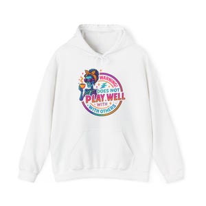 May include: White hoodie with a front graphic. The graphic features a skeleton with sunglasses and a headscarf holding a cup. The text reads "WARNING! DOES NOT PLAY WELL WITH OTHERS" in a colorful, circular design.