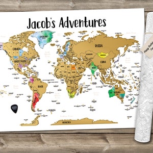 May include: A gold world map with a scratch-off coating, titled "Jacob's Adventures". The map is on a white background and has a colorful watercolor design on the continents. The map is rolled up and tied with a string. A tag is attached to the string that says "Happy Birthday Jacob! From Aunt Emma."