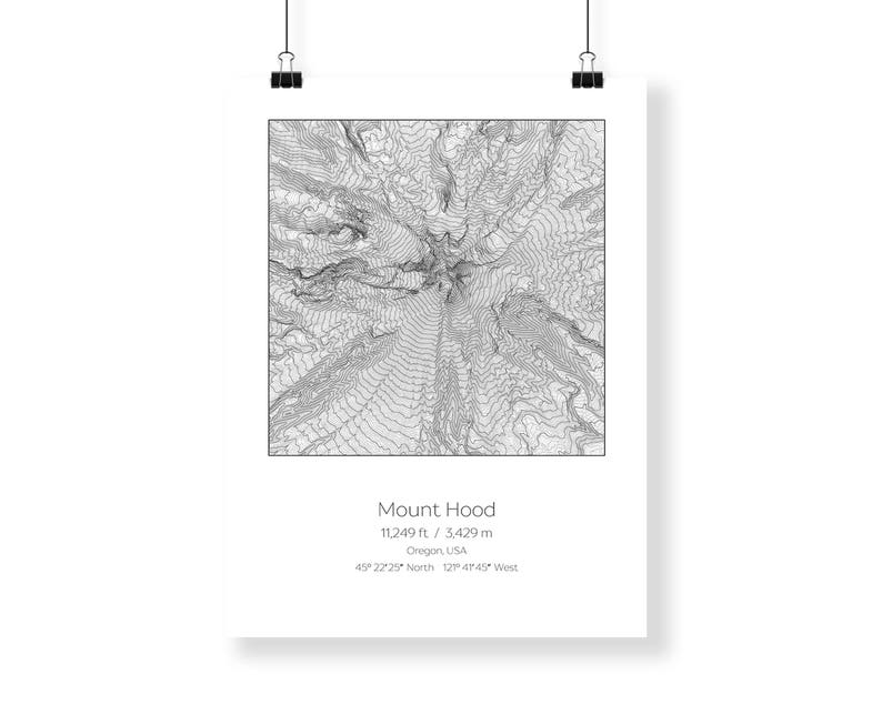 May include: A black and white topographic map of Mount Hood, Oregon, USA. The map shows the mountain's elevation contours and surrounding terrain. The text "Mount Hood", "11,249 ft / 3,429 m", "Oregon USA", "45&deg; 22'25" North 121&deg; 47'45" West" is printed below the map.
