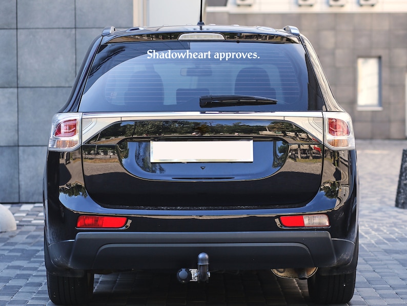 May include: A black SUV with a rear window sticker that reads "Shadowheart approves."