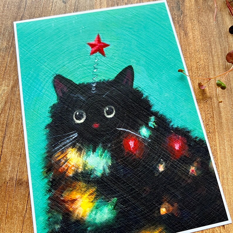 Puede incluir: Un gato negro con una estrella roja en la cabeza est&aacute; decorado con luces de colores, que se asemejan a un &aacute;rbol de Navidad.