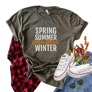 May include: A gray t-shirt with the text "SPRING SUMMER pumpkin WINTER" in white and orange lettering.
