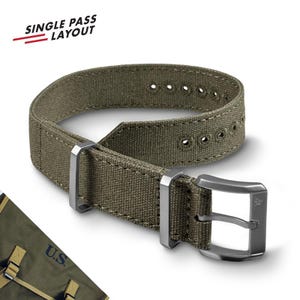 May include: An olive green canvas watch strap featuring a single pass layout, metal buckle, and two metal keepers. The strap has reinforced stitching and metal-rimmed adjustment holes. The text "SINGLE PASS LAYOUT" appears in the upper left corner.