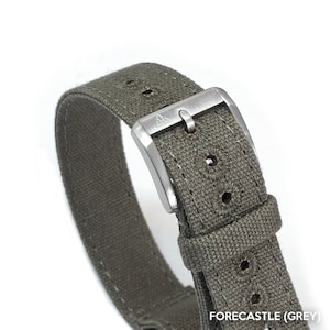 May include: A gray canvas watch strap with a silver buckle. The buckle has the word "FORECASTLE" and the word "(GREY)" printed on it.