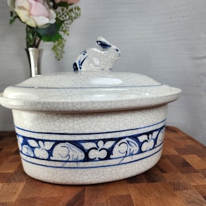 May include: A white ceramic mug with a black handle and the text "But First, Coffee" in a black, handwritten-style font. The mug is on a white surface.