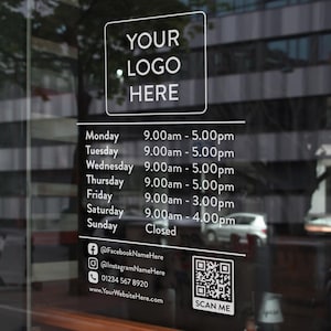May include: A shop window displaying opening hours and contact details in white text. The text includes "YOUR LOGO HERE", daily opening times, social media handles, a phone number, a website address, and a QR code with the words "SCAN ME".