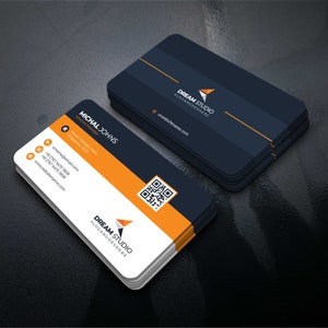 Op de afbeelding: Een visitekaartje met een zwart en oranje kleurenschema. De kaart bevat de tekst "DREAM STUDIO" en "SLOGANGOESHERE" in witte tekst. De kaart bevat ook een QR-code en contactgegevens voor Michal Johns, Solution Manager.