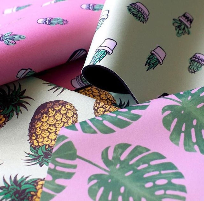 May include: Three different fabric swatches with various patterns. The first swatch is pink with a cactus pattern. The second swatch is green with a potted plant pattern. The third swatch is pink with a monstera leaf pattern.