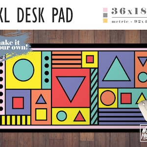 May include: A large geometric desk pad with a colorful design featuring circles, squares, triangles, and stripes. The pad is 36 inches by 18 inches and is made of a durable material. The text "make it your own!" is written in a white box on the top left corner of the pad. The text "No Bad Mondays" is written in a white box on the bottom right corner of the pad.