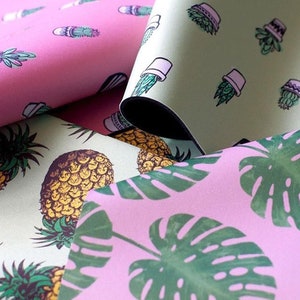 May include: Three different fabric swatches with various patterns. The first swatch is pink with a cactus pattern. The second swatch is green with a potted plant pattern. The third swatch is pink with a monstera leaf pattern.