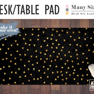 May include: Black desk pad with a gold triangle pattern. The text "make it your own!" is on the pad. The pad is on a wood surface. The text "No Bad Mondays" is on a white mouse.