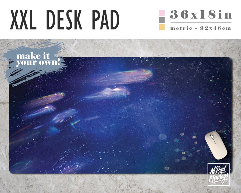 May include: A large, blue desk pad with a galaxy-like design featuring streaks of light and a subtle sparkle effect. The pad measures 36x18 inches and has the text "make it your own!" in the top left corner.