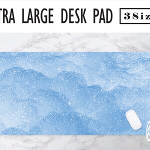 May include: A light blue desk pad with a glitter finish. The desk pad has a subtle wave pattern. The text "EXTRA LARGE DESK PAD" and "3 Sizes" is at the top of the image.