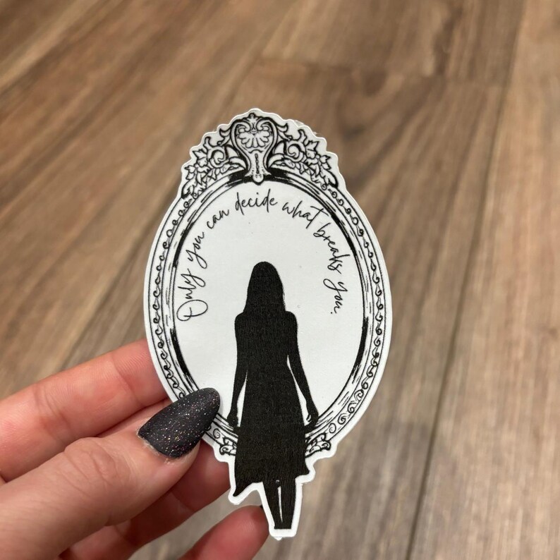 May include: Black and white sticker of a mirror with an ornate frame. The mirror reflects a silhouette of a person with the text "Only you can decide what breaks you."