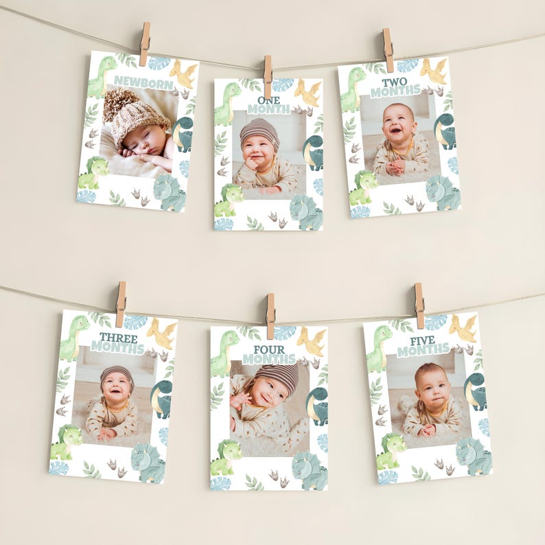 Pu&ograve; includere: Sei cartoline rettangolari per tappe fondamentali con illustrazioni ad acquerello di dinosauri e fogliame, ognuna con una foto di un bambino e il testo Newborn, One Month, Two Months, Three Months, Four Months e Five Months, appese a un filo.