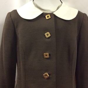 May include: A brown blazer with a white Peter Pan collar and gold square buttons.