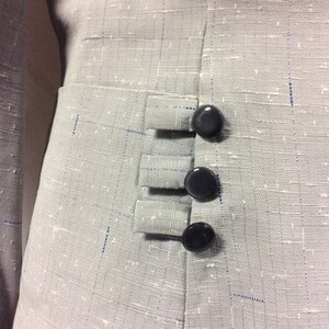 May include: A grey blazer with a textured fabric and three black buttons on the side.