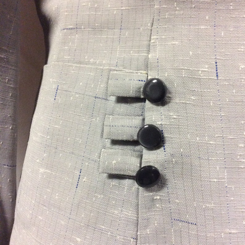 May include: A grey blazer with a textured fabric and three black buttons on the side.