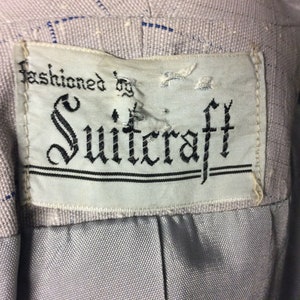 May include: A white label with black text that reads "fashioned by Suitcraft".