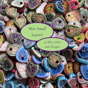 May include: A collection of small, leaf-shaped beads in various colors, including blue, purple, green, and red. The beads have intricate designs and are scattered across the image. Text on the image reads "New Small Leaves!" and "14 New Colors and Designs."