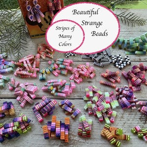 Puede incluir: Una colección de cuentas rectangulares con rayas multicolores en varios patrones, incluyendo rosa, naranja, verde, morado, y blanco y negro. Las cuentas están dispuestas en pequeños montones, con texto visible que dice Beautiful Strange Beads y Stripes of Many Colors.