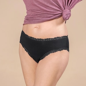 Könnte beinhalten: Schwarze Unterwäsche mit Spitzenbesatz. Die Unterwäsche ist aus einem weichen, bequemen Stoff.