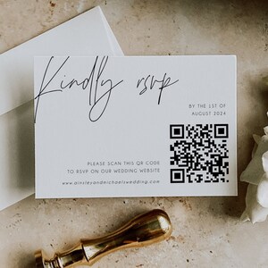 May include: A white RSVP card with black text that reads "Kindly RSVP by the 1st of August 2024". A black and white QR code is below the text. The text "Please scan this QR code to RSVP on our wedding website www.ainsleyandmichaelswedding.com" is below the QR code.