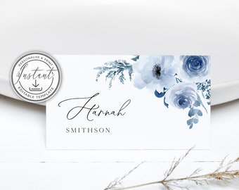 May include: A white place card with a blue watercolor floral design. The name "Hannah Smithson" is printed in black script font.