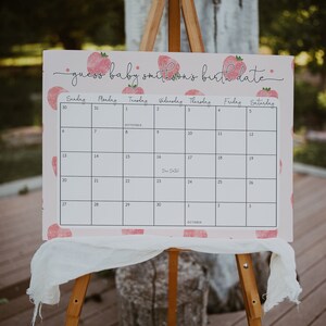 Puede incluir: Un calendario rosa y blanco con un patr&oacute;n de fresas. El calendario se titula "adivina la fecha de nacimiento del beb&eacute; smithson". La fecha de parto est&aacute; marcada el 16 de septiembre.